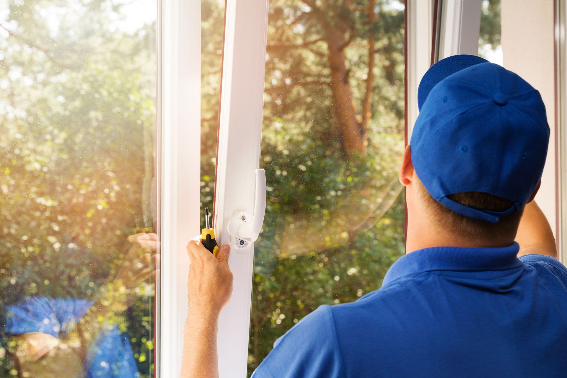worker in blue uniform installing new plastic pvc window