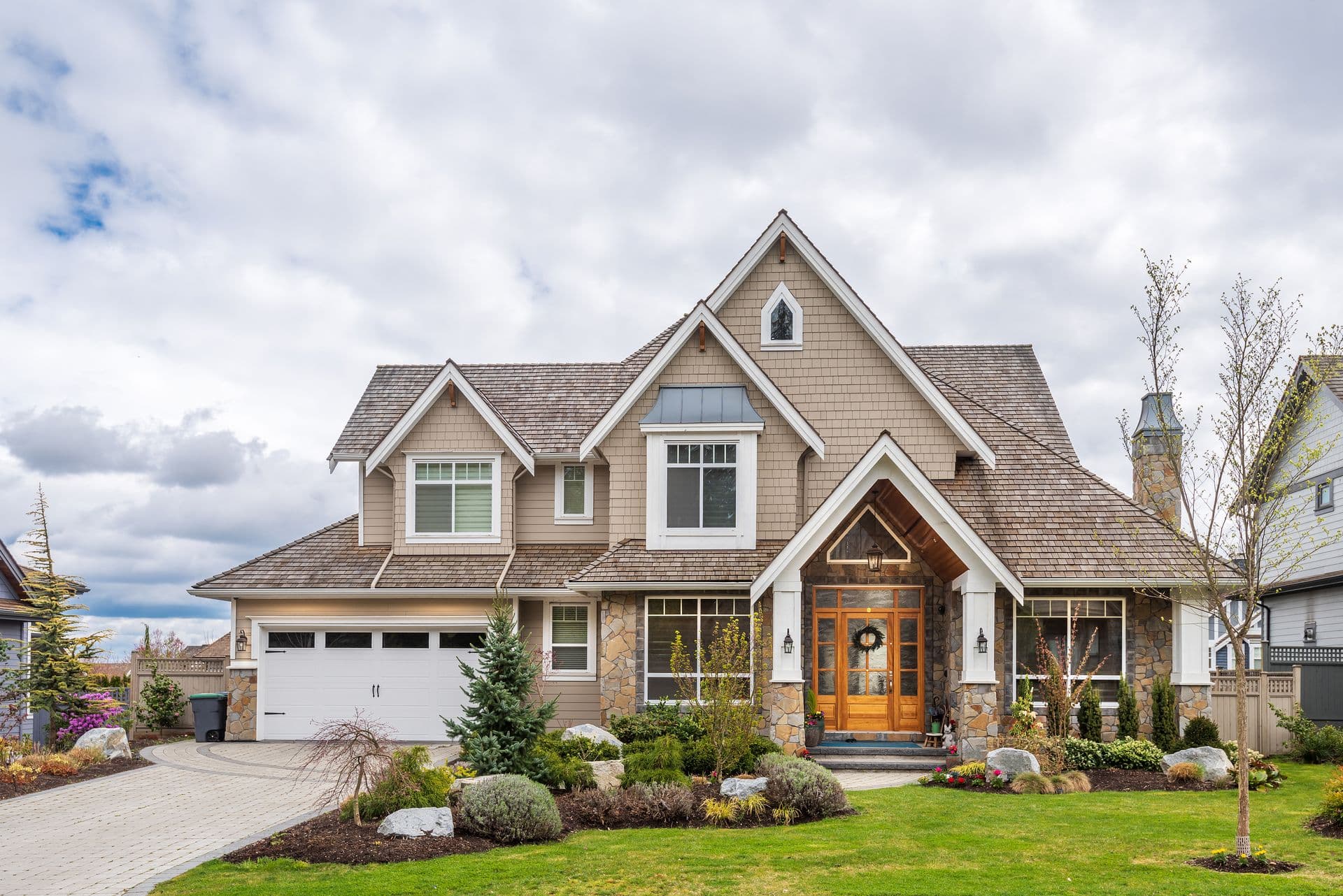Beautiful exterior of newly built luxury home. Yard with green grass and walkway lead to front entrance.