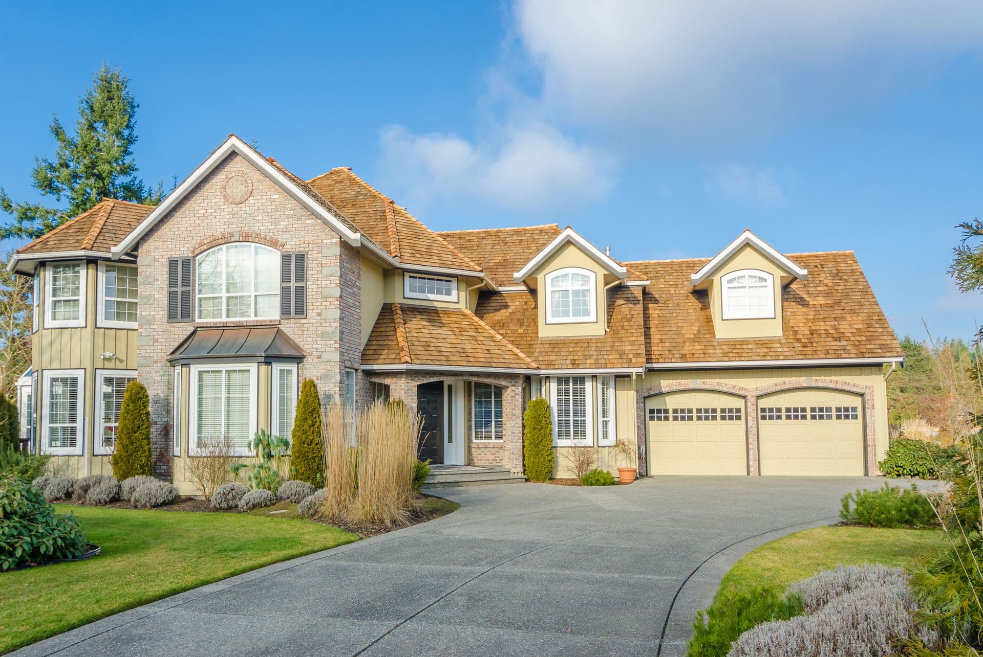 Custom built luxury house with nicely trimmed front yard, lawn in a residential neighborhood. Home exterior.