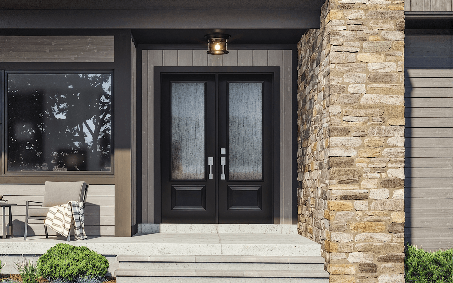 Exterior entryway view featuring modern black double front doors with large textured glass panes and sleek silver handles, set within a grey-sided house framed by a stacked stone wall, concrete porch, and patio seating.